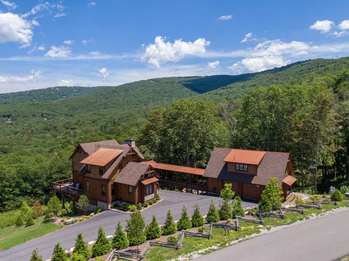 A picturesque two-story wooden house is nestled among rolling mountains and landscaped gardens. The exterior highlights spacious grounds, perfect for outdoor play and gatherings. The scene evokes the spirit of family adventure and the natural beauty of the Eagles Nest community.
